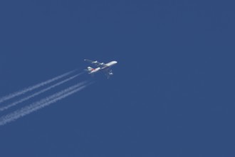 Airbus A380 jet passenger aircraft of Emirates airlines with a vapour trail or contrail flying in a