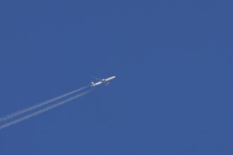 Airbus jet passenger aircraft of Emirates airlines flying with vapour trails or contrails behind in