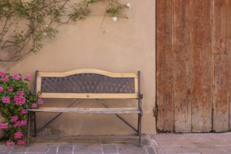 Bench in front of a house wall with flowers, Tuscany, Italy
