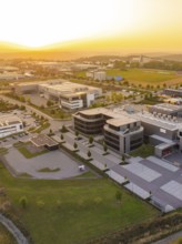 Modern commercial building with car park in a rural setting at sunset, industrial area Wolfsberg