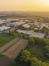 Aerial view of a rural industrial plant with fields and trees at sunset, industrial area Wolfsberg