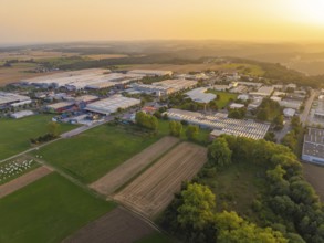 Industrial warehouses and fields in a vast rural landscape at sunset, Wolfsberg Nagold industrial
