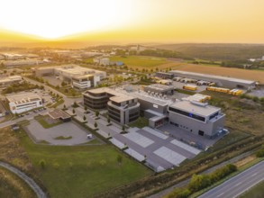 Modern office complex with extensive car parks and fields at sunset, Wolfsberg Nagold industrial
