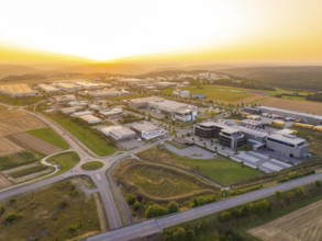 Wide view of an industrial area at sunset, surrounded by fields and forests, industrial area