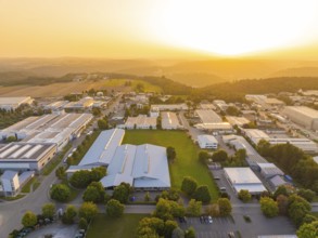 Industrial complex with surrounding green areas and fields at sunset, industrial area Wolfsberg