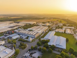 Industrial plants next to fields and forests in the warm light of the sunset, industrial area