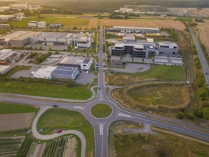 Industrial area with central roundabout, adjacent to fields and modern buildings, industrial area