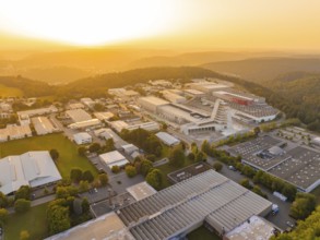 Extensive industrial complex embedded in wooded hills at sunset, industrial area Wolfsberg Nagold,