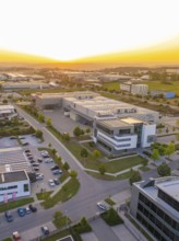 Industrial area at sunset with modern buildings, orderly streets and car parks, industrial area