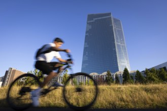 A cyclist rides past the European Central Bank (ECB) in Frankfurt am Main, Frankfurt am Main,
