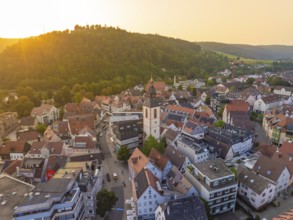Panorama of an urban environment with a church surrounded by hills in the evening light, Nagold,