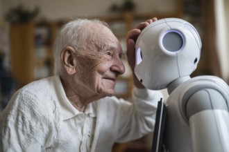 An elderly man in a nursing home smiles and communicates with a humanoid robot, carer robot, symbol