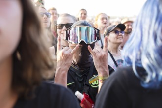 A festival visitor with a ski mask in the audience at the Highfield Festival on Saturday,
