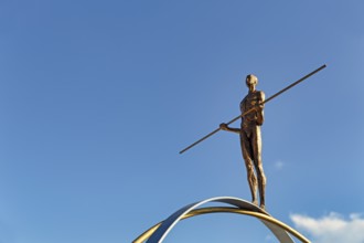 Sculpture Balance by the artist Martina Ondáková in front of a blue sky, human figure balanced,
