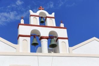 Bell tower of an orthodox church in typical Cycladic architecture with whitewashed walls and red