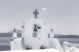 White bell tower of an orthodox church by the sea, monochrome, Oia, Thira, Santorini, Cyclades,