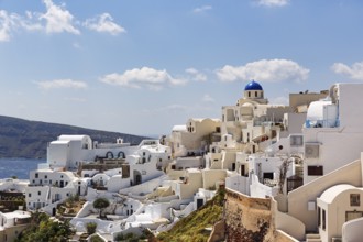 White holiday homes, orthodox church with blue dome on the edge of the caldera, Cumulus, Oia,