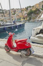 Red vespa scooter parked at Gialos harbour, Gialos, Symi Island, Dodecanese Islands, Greece