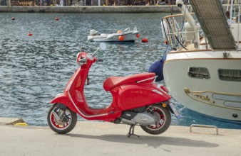 Red vespa scooter parked at Gialos harbour, Gialos, Symi Island, Dodecanese Islands, Greece