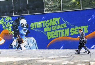 People on the move in the Königstraße pedestrian zone in Stuttgart. Construction fence with the