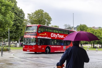 Stuttgart city tour. City tour in a red double-decker in rainy weather at Schlossplatz. City view