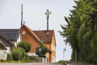 Mobile phone mast on a house roof in a rural area. Ohmden, Baden-Württemberg, Germany