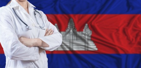 Doctor with crossed arms on Cambodia flag. Cambodia health and care concept. Female doctor on