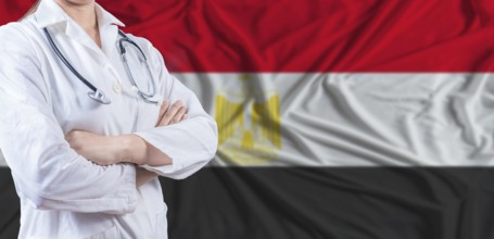 Doctor with crossed arms on Egypt flag. Egypt health and care concept. Female doctor on Egypt flag