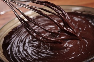 A bowl of chocolate dough, a whisk for whipping, baking, structure and consistency, homemade, top