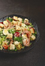 Caesar salad with tiger prawns, shrimp salad, lettuce leaves, quail eggs, cherry tomatoes, parmesan