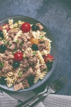 Fusilli pasta salad with canned tuna, cherry tomatoes and olives, parmesan, microgreens, homemade,
