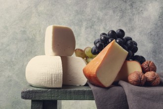 Georgian cheese, Imeretian and smoked suluguni, grapes, nuts, on a cutting board, Georgian cuisine,