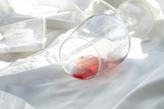 Glass, with pink wine, spilled on a white shirt, close-up, selective focus, no people, concept, top