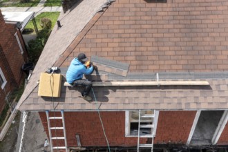 Detroit, Michigan - Workers re-roof a house they are remodeling in the Morningside neighborhood