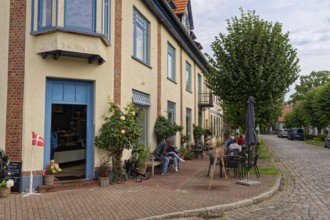 Cafe in the town centre, on the corner of Neuer Damm and Lange Straße, both with cobblestones.