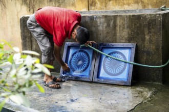 Employee of the Assam Khadi and Village Industries Board cleaning Ashoka Stambh screen printing
