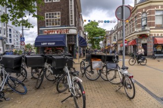 Riding a bike in the city centre of Groningen, old town, parked courier bikes, food delivery