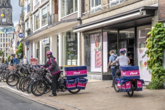 Bicycle traffic in the city centre of Groningen, old town, branch of the food delivery service