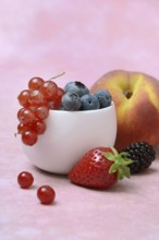 Various fruits in peel, redcurrant, peach, strawberry, blueberry, blackberry