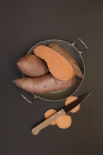Sweet potatoes in their skins with kitchen knife, Ipomoea batatas