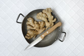 Ginger, ginger tubers in bowl with kitchen knife