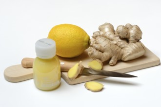 Ginger root and lemon on cutting board and ginger shot