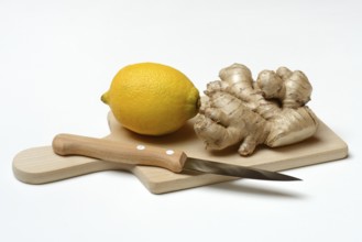 Ginger root and lemon on cutting board with knife, Zingiber officinale