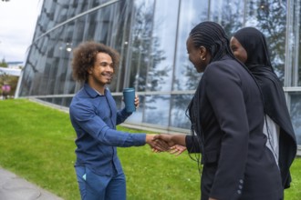 Diverse business professionals meeting and exchanging a friendly handshake outdoors in a modern