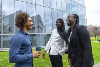 Diverse group of business colleagues, including a man holding a reusable cup and two women,