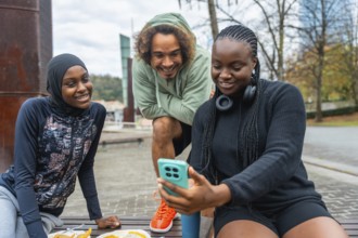 Three diverse young adults, a woman in a hijab, a man with curly hair, and a woman with braids,
