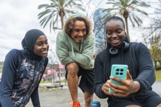 Group of diverse young friends, including a woman wearing a hijab, bonding and sharing a joyful