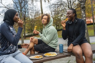 Group of diverse urban friends enjoying a casual snack from a street vendor while sitting outdoors
