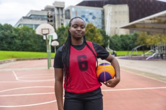 Young black woman wearing a red number six jersey and black athletic attire, standing confidently