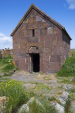 Old Armenian stone church with vaulted entrance surrounded by green landscape, Noratus cemetery,